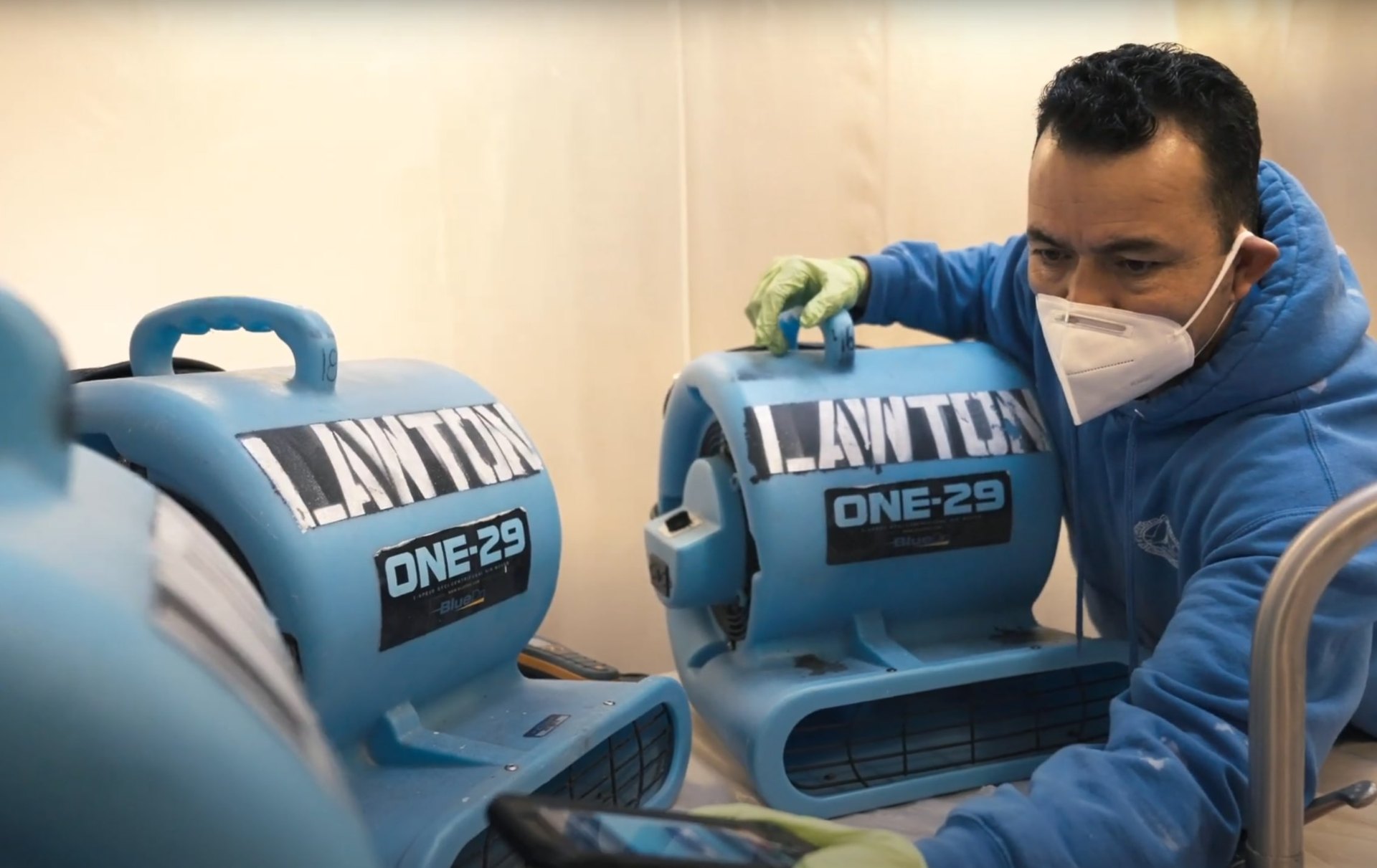 Professional water damage restoration technician using advanced drying equipment