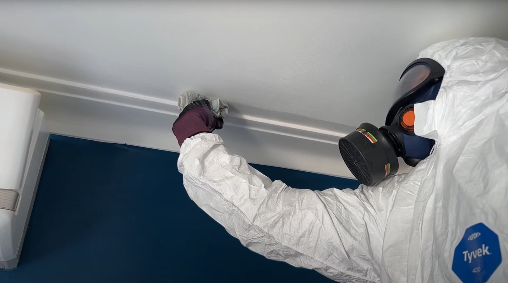 Two water damage restoration technicians in protective suits working together