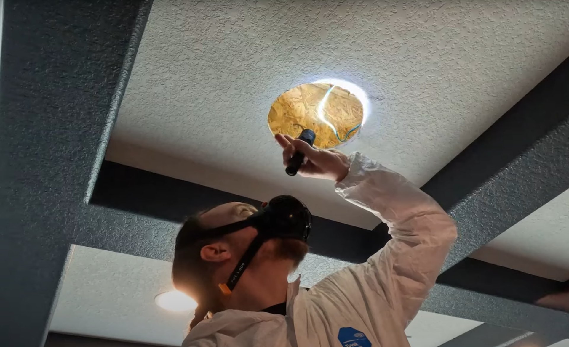 Water damage restoration specialist using thermal imaging to detect moisture in ceiling